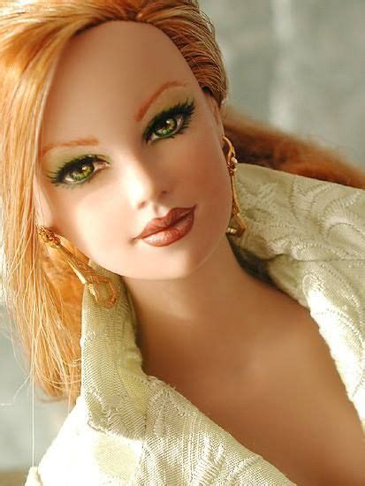a close up of a doll with red hair and green eyes wearing gold hoop
