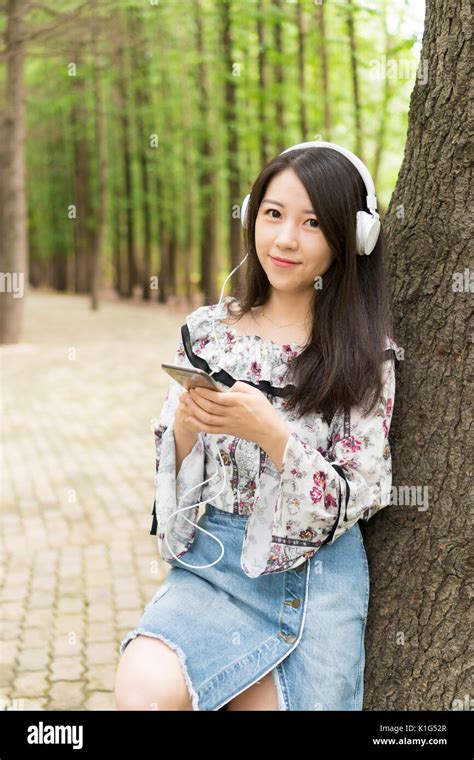Hermosa Joven Asian Girls En Maderas Escuchar Música Fotografía De