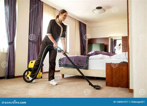 A Man Who Is On The Hotel Cleaning Crew Staff Is Smiling With A Towel
