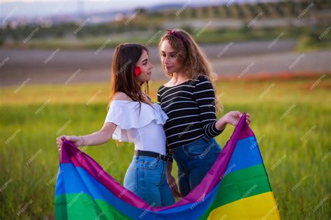 piękna młoda para lesbijek z tęczową flagą równe prawa dla społeczności lgbt zdjęcie premium
