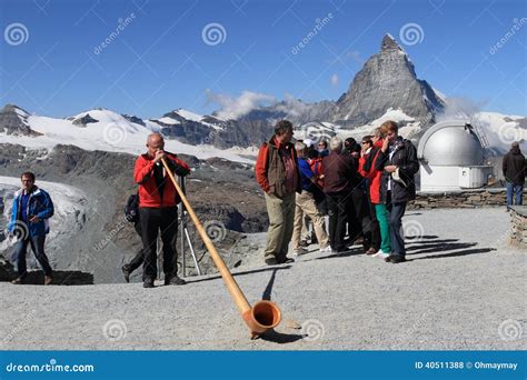 Hombre Suizo Que Sopla El Cuerno Alpino Tradicional Foto De Archivo