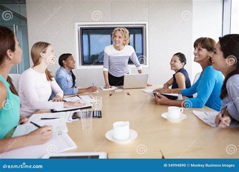 Group Of Businesswomen Meeting Around Boardroom Table Stock Photo