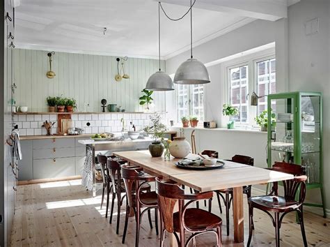 A modern white scandinavian kitchen with a large kitchen island with a black countertop, pendant lamps and a glass buffet. Before & After: Rustic Scandinavian Living Room Design ...