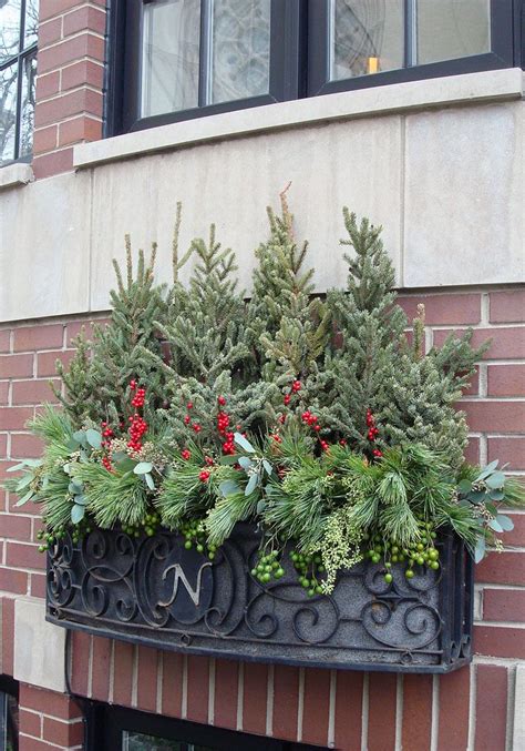 Carefully insert twigs, reeds, and dried flowers to fill in the spaces. winter, decor, window box, spruce tops, evergreens, urban ...