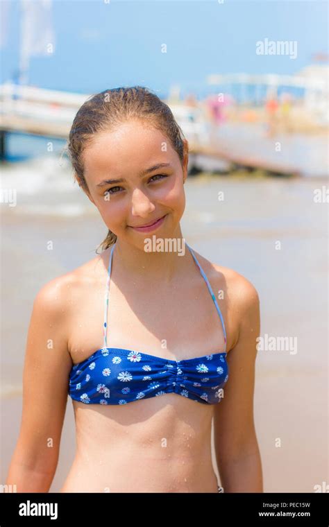 Hübsches Mädchen im Bikini am Strand lächelnd in Kamera