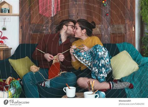 Junges Paar Macht Handarbeiten Und Küsst Sich Auf Der Couch Ein Lizenzfreies Stock Foto Von