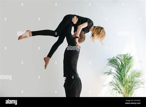 Couple Doing Gymnastic Form He Is Holding Her On Strtaight Arms By The