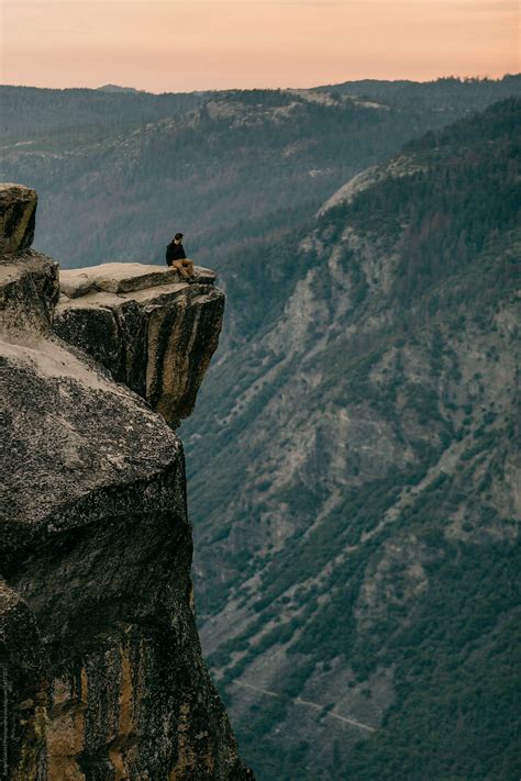 Man Standing At The Edge Of A Mountain Cliff In Yosemite Stocksy United
