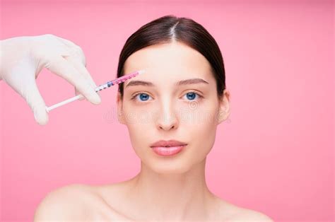 A Young Attractive Lady Gets A Botox Injection In The Forehead Stock