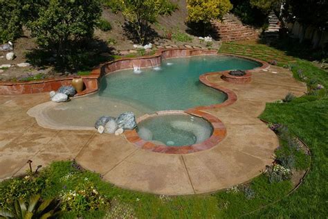 Freeform Swimming Pool With A Hot Tub And Water Features On The Side