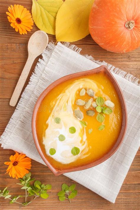 Traditional Pumpkin Cream Soup With Seeds In Clay Bowl On A Brown