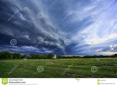 Storm Dark Clouds Flying Over Field With Green Grass Stock Image