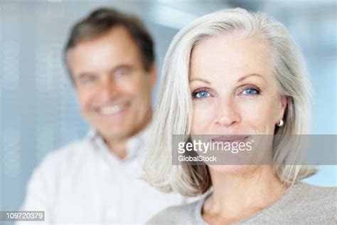 Femme Dâge Mûr Souriant Avec Homme En Arrièreplan Photo Getty Images