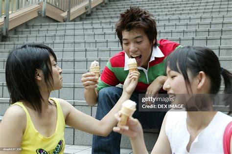 Teenagers Sitting Together Eating Ice Cream High Res Stock Photo