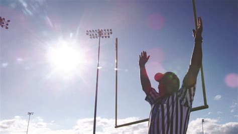 A Football Referee Walks Into Frame And Throws His Arms Over His Head