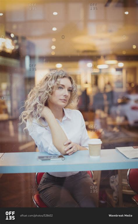 Thoughtful Woman Sitting At Counter Stock Photo Offset