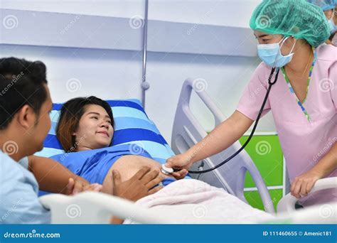 Nurse Examining Pregnant Woman With Stethoscope At Maternity Ward Stock