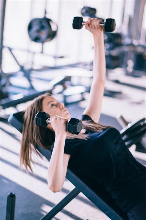 Young Beautiful Woman Doing Exercises With Dumbbell In Gym Stock Photo