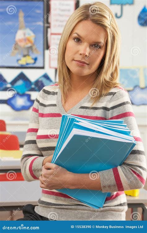 Female Teacher Sitting At Desk In Classroom Stock Photo Image 15538390