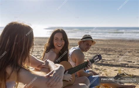 Three Friends Relaxing Together On The Beach Selective Focus Relaxed Stock Photo