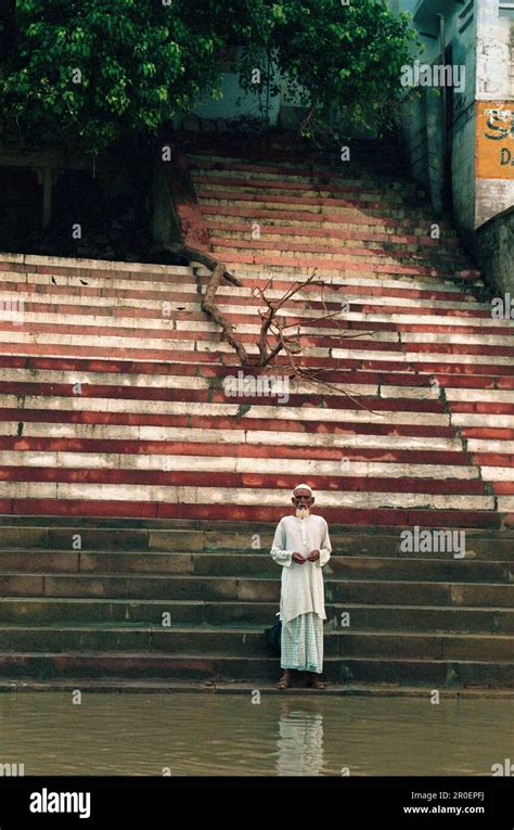 praying pilgrim standing on stairs at the river ganges ghat varanasi uttar pradesh india