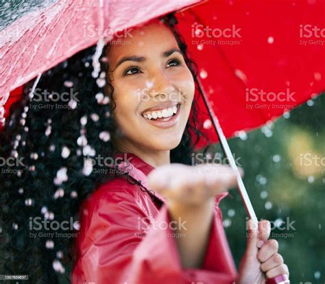 Shot Of A Beautiful Young Woman Standing In The Rain With An Umbrella