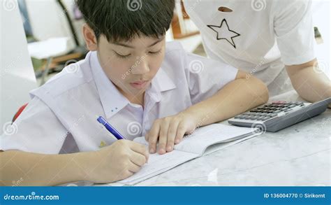 slow motion of asian mother helping her son doing homework on white table stock footage video