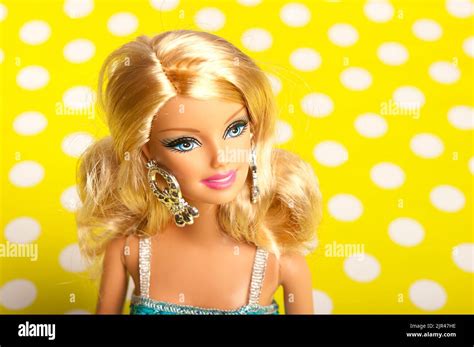 blond barbie with blue dress on yellow polka dots background stock
