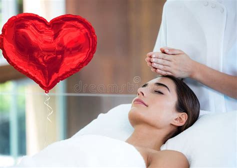 Composite Image Of Red Heart Shaped Foil Balloon Against Woman Receiving A Head Massage At A Spa