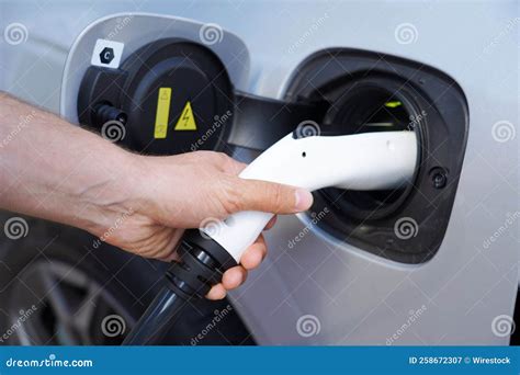 Closeup Shot Of A Man Charging His Electric Car At A Charging Station