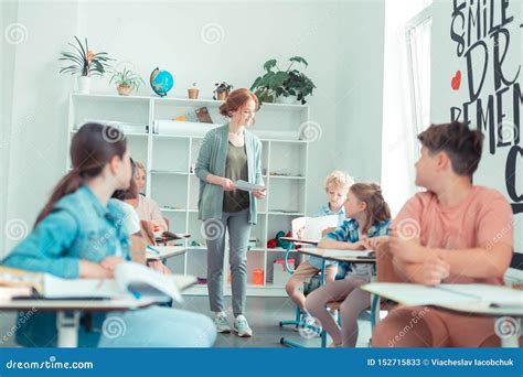 Teacher Giving Pupils Sheets Of Paper With The Test Stock Image