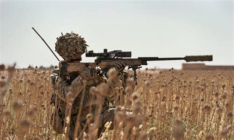 British Army Sniper Looks Through The Scope Of His L115a3 Sniper Rifle