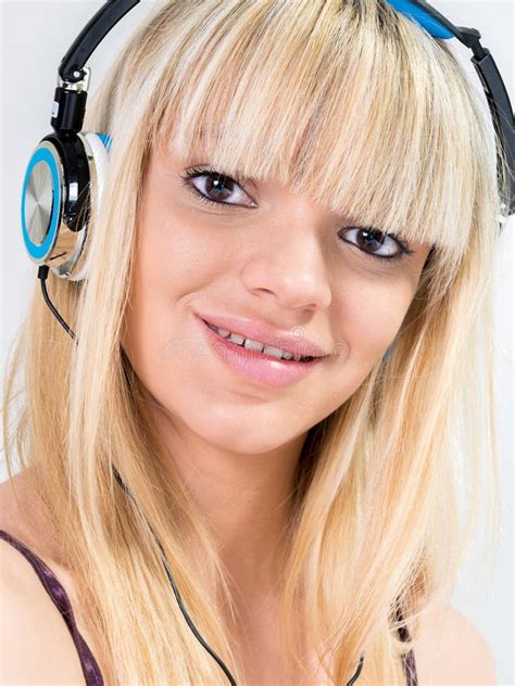 Blond Teenage Girl Listening To Music With Blue Headphone Stock Image
