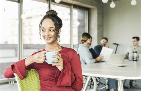 Lächelnde Junge Geschäftsfrau Bei Einer Kaffeepause Während Einer Besprechung Im Büro