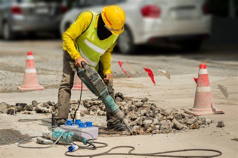 Worker Drilling Concrete Driveway With Jackhammerman Repairing Road