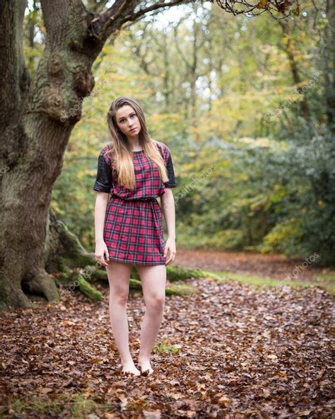 Portrait Of A Beautiful Teenage Girl Standing In A Forest Stock Photo