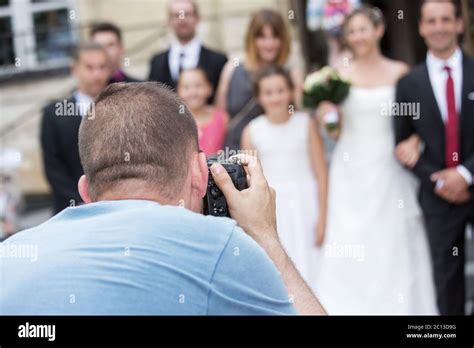 Wedding Photographer In Action Taking A Picture Of Group Of Guests