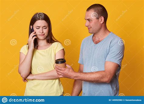 Sad Woman Looks Down With Upset Expression While Speaking Via Smart Phone With Her Friend