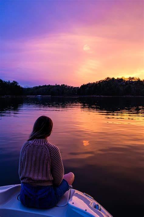 Photo Of Woman Sitting On Boat While Looking At Sunset · Free Stock Photo