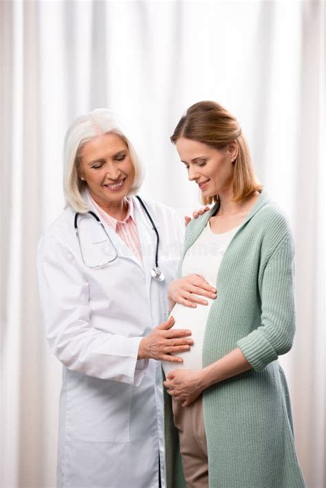 Doctor Examining Pregnant Woman During Medical Consultation Stock Image