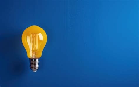 Premium Photo Single Yellow Light Bulb Glowing Against A Blue Backdrop