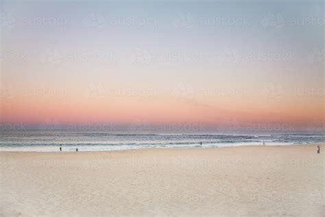 Image Of Beautiful Sunset Over A Sandy Beach With People In The