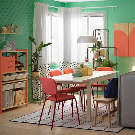 A Dining Room With Colorful Chairs And A White Table
