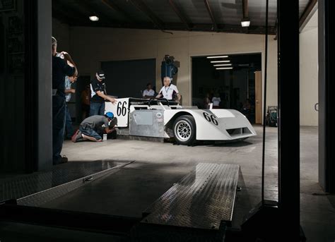 Some People And A Race Car In A Garage