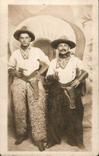 Two Men Dressed As Cowboys Holding Pistols Wearing Wooly Chaps