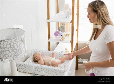 Mother Changing The Diaper Of Her Baby Stock Photo Alamy