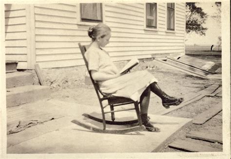 Woman In Rocking Chair Reading A Book On The Porch Photo Circa