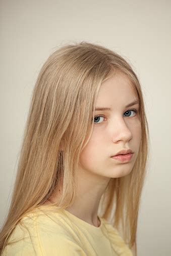 Studio Portrait Of A Blonde Teen Girl In A Yellow Tshirt