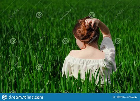 Solo Outdoor Activities Back Shot Of Young Brunette Woman In White Top Sitting In Green Wheat