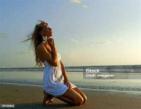 Gorgeous Woman In White Dress Kneel On The Beach Stock Photo Download